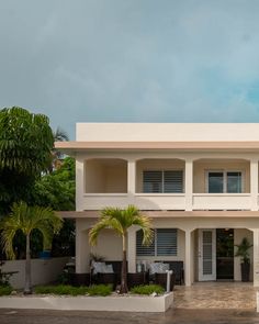 a large white building with palm trees in front of it