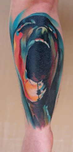 a man's leg with a colorful tattoo on it and an image of a dog