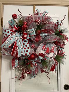 a red and white christmas wreath on the front door