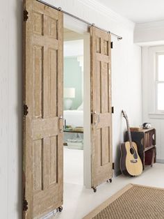 an open door leading to a bedroom with a guitar on the floor next to it