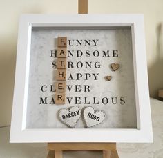 a white frame with two wooden hearts and words on the front saying fun, handsome, strong, strong, happy, clever, marvelous