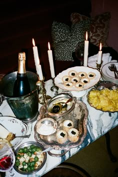 a table topped with lots of food and candles