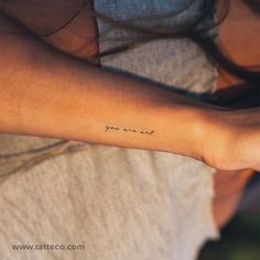 a woman's arm with the word you are not written on it, in cursive font