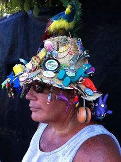 a woman wearing a hat made out of many different things on her head and ear rings