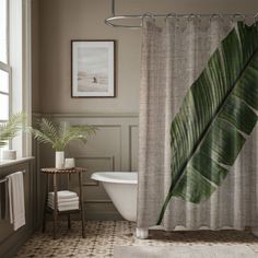 a bathroom with a bathtub, sink and shower curtain in the shape of a leaf