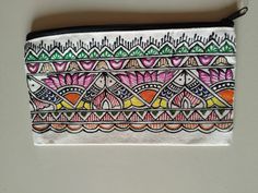 an embroidered pouch with colorful designs on the front and side, sitting on a white surface