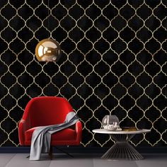 a red chair sitting in front of a black wall with gold trellis on it