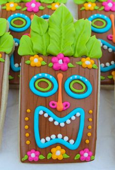 decorated cookies are arranged in the shape of people's faces with leaves and flowers on them