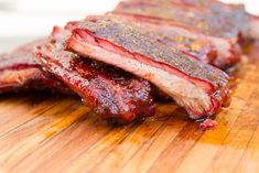 two pieces of meat sitting on top of a wooden cutting board with ketchup