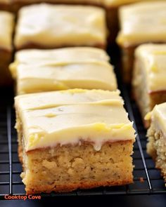 there are many pieces of cake on the cooling rack and it is frosted with icing