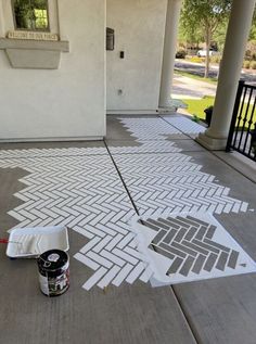 a paint can is sitting on the ground next to a sidewalk that has been painted