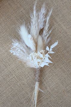 some white feathers are tied together on a burlock