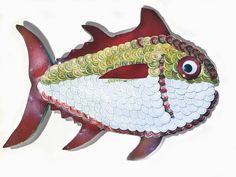 a red and white fish with big eyes on it's head is hanging from the wall