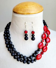 Make a real statement with this OOAK colorful necklace set. Both vintage and new glass beads, Czech glass beads, and marbled red resin beads in hues of shiny black, matte black, and dark red are strung onto 2 wires in this offset design at varying lengths. Necklace is finished with decorative silver bead caps and a large lobster clasp.  The necklace measures 19 inches long with a chain measuring 2 inches included for comfort.  Matching beaded drop earrings are hung on 925 silver ear wires. Black Glass Jewelry With Large Beads, Black Glass Round Bead Jewelry, Black Glass Round Beads Jewelry, Black Glass Beaded Jewelry, Black Glass Polished Beads Jewelry, Black Glass Jewelry With Polished Beads, Black Czech Glass Jewelry With Round Beads, Bold Resin Jewelry For Gifts, Bold Resin Jewelry For Gift