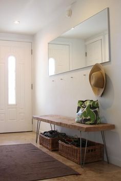 there is a bench and mirror in the hallway next to the door with shoes on it