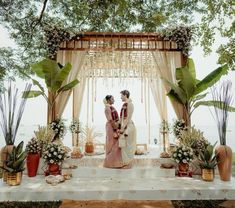 two women standing in front of an outdoor ceremony