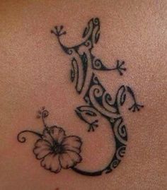 a lizard tattoo on the back of a woman's stomach, with a flower