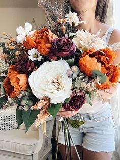 a woman holding a bouquet of flowers in her hands