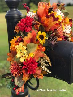 a mailbox decorated with fall flowers and leaves