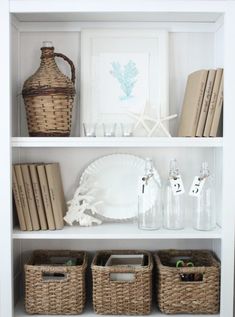 a white bookcase with wicker baskets and books