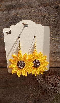 "Embroidered Sunflower Earrings. These double layer sunflower shaped earrings are machine embroidered with polyester embroidery thread. They are set with gold colored fish hook style ear wires and hang about 2.5\" from the ear lobe. They are approximately 1.75\" wide. Please choose from 1 of 2 styles. The first is embroidered with a darker honey colored thread and the center of the flower is enhanced with 10 sparkling rhinestones. The 2nd style is just as beautiful but more subtle without the rhinestones, and is embroidered with a brighter yellow thread." Gold Sunflower Adjustable Flower Earrings, Handmade Flower Earrings In Gold For Summer, Gold Earrings With Handmade Flowers For Summer, Summer Embroidered Jewelry For Gift, Summer Sunflower Design Earrings, Summer Sunflower Design Flower Earrings, Summer Flower Earrings With Sunflower Design, Adjustable Sunflower Design Earrings For Summer, Sunflower Earrings