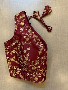 Alluring dark maroon sleeveless blouse with golden embroidery. Buy designer blouse in USA from Pure Elegance. Disclaimer: The actual product may vary slightly from the image. These are custom orders, hence expect slight variation in color, placement of the motif or buta. ESTIMATED DELIVERYBecause this is a custom order, it would take about 4 weeks from the date of purchase. RETURN POLICY: This product is a custom order and cannot be returned or exchanged. Embroidered Sleeveless Traditional Wear For Festivals, Sleeveless Embroidered Traditional Wear For Festivals, Sleeveless Embroidered Blouse For Festivals, Sleeveless Embroidered Traditional Wear For Festive Occasions, Festive Sleeveless Embroidered Traditional Wear, Traditional Sleeveless Embroidered Fabric For Festivals, Sleeveless Traditional Wear With Intricate Embroidery For Festive Occasions, Sleeveless Festive Blouse Piece With Intricate Embroidery, Traditional Floral Embroidered Sleeveless Blouse