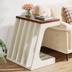 a coffee table with a book on it next to a couch and potted plant