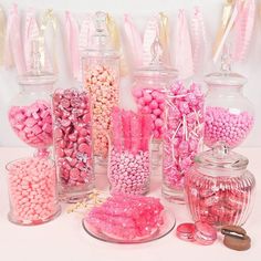 pink and white candies in glass jars on a table