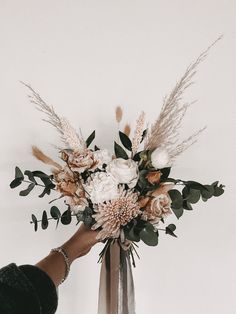 a person holding a bouquet of flowers in their hand