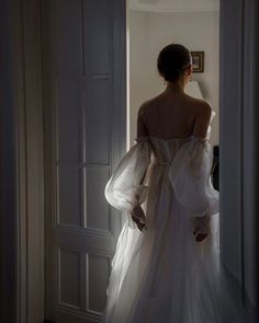 the back of a woman's dress as she stands in an open doorway