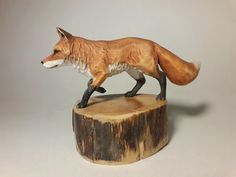 a figurine of a fox standing on top of a tree stump