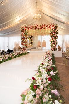 a white dance floor decorated with flowers and greenery