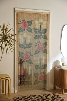 a living room with a rug, chair and window covered in bamboo blinds next to a potted plant