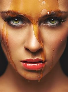 a woman's face is covered in chocolate and has her eyes painted orange with yellow