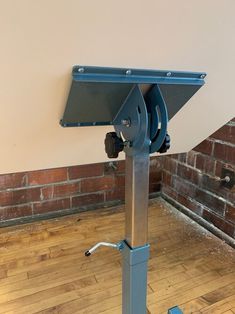 a metal object on a wooden floor in front of a brick wall and wood floor