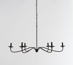 a black chandelier with five candles hanging from it