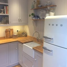 a white refrigerator freezer sitting inside of a kitchen next to a wooden counter top