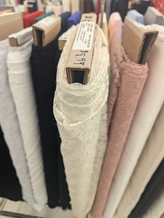 there are many different types of fabrics on the racks in this store, including one for men's shirts and one for women's pants