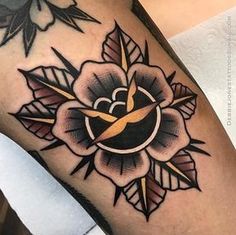 a black and yellow flower tattoo on the leg with gold trimmings is shown