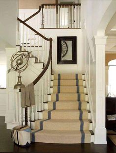 the stairs in this house are made of wood and have wrought iron handrails