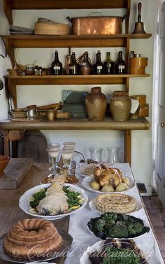 a table filled with lots of food on top of a wooden table next to a refrigerator