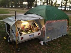 a camper van is parked in the grass with its door open and lights on