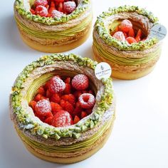 three cakes with strawberries in them on a table