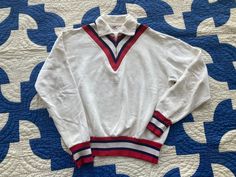 "Excellent 1950s Akom all cotton sweatshirt with color block chevron neckline and striped cuffs! In good condition with a small hole on one sleeve, holes on the cuffs and some discoloration. Please see photos. Shoulder to Shoulder: 19\" Underarm to Underarm: 23\" Length: 23\" Sleeve: 24\" Please ask any questions before purchasing, especially concerning fit or condition. All items are vintage and in condition as described. Shipping via USPS Priority Mail unless otherwise agreed upon. All sales final, no returns- Thank You from Collecting Dust!" Retro Collared Cotton Sweater, Retro Cotton Collared Sweater, Retro White Top With Ribbed Collar, White Retro Top With Ribbed Collar, Retro Cotton Sweatshirt With Ribbed Collar, Retro Cotton Sweatshirt, Retro Cotton Tops With Ribbed Cuffs, Retro White Sweatshirt With Ribbed Cuffs, Vintage White Sweater With Ribbed Cuffs