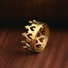 a gold crown ring sitting on top of a wooden table