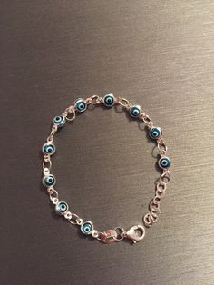 "Silver blue evil eye bracelet for babies and young children. The bracelet is 4.25\" long with a 0.50\" extension. The bracelet can be clasped smaller by hooking the clasp to any of the other loop rings in between the evil eyes.  Sterling Silver, 925.  Ships in a gift box." Ojo Bracelets Baby, Cheap Resizable Blue Evil Eye Bracelet, Adjustable Hypoallergenic Silver Evil Eye Bracelet, Adjustable Blue Evil Eye Charm Bracelet, Adjustable Blue Evil Eye Bracelet, Nickel Free, Adjustable Blue Evil Eye Bracelet Nickel Free, Adjustable Nickel-free Blue Evil Eye Bracelet, Adjustable Hypoallergenic Evil Eye Bracelet, Adjustable Hypoallergenic Blue Charm Bracelet