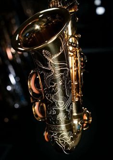 a close up view of a saxophone with intricate designs on it's body and neck