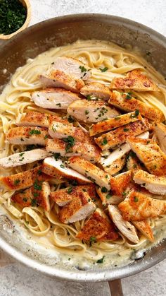 a pan filled with chicken and pasta on top of a table