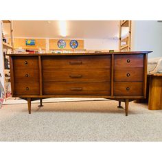 a wooden dresser sitting on top of a carpeted floor