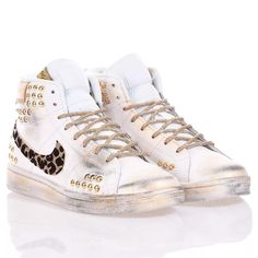 Nike Hi Leo Studs is the custom women's sneaker for a street-inspired look. The iconic Nike swoosh is adorned with sparkling animal print leopard glitter in perfect contrast with the gold studs matched to the gold lurex laces. The final touch in full Mimanera style is the vintage-effect gold and black stripes. &nbsp;Nike Hi Leo Studs will also come with its original white laces. High-top Leopard Print Sneakers For Streetwear, Leopard Print High-top Sneakers For Streetwear, Gold Leather Custom Sneakers For Streetwear, Gold Leather Sneakers For Streetwear, Gold High-top Casual Custom Sneakers, Pretty Shoes Sneakers, Nike Swoosh, Final Touch, Sneaker Wedge